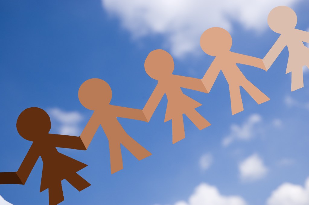 Diverse paperchain cutout against a blue sky